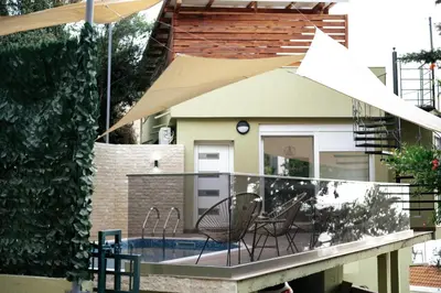 a balcony with a table and chairs and an umbrella at Resort Stikovic in Dobra Voda
