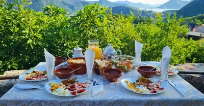 a blue table with plates of food on it at Dembelija Rooms in Virpazar
