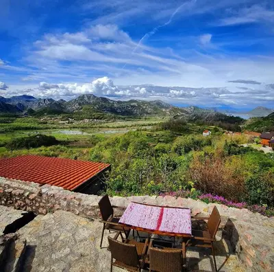 a table and chairs on top of a mountain at Dembelija Rooms in Virpazar