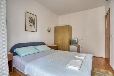 a bedroom with a large bed and a tv at Guest House Vukovic in Petrovac na Moru
