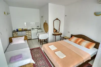 a bedroom with two beds and a mirror at Guest House Vukovic in Petrovac na Moru