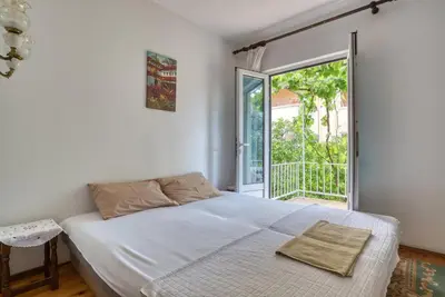 a bedroom with a bed and a large window at Guest House Vukovic in Petrovac na Moru