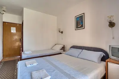 a small room with a bed and a tv at Guest House Vukovic in Petrovac na Moru