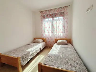 two beds in a room with a window at Apartment Adrialux in Budva