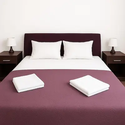 a bed with two white pillows on a purple blanket at Apartment Adrialux in Budva