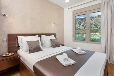 a bedroom with a large bed with a window at De Lux Apartments Sirena in Kotor