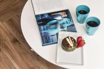 a table with a book and a cake and strawberries at De Lux Apartments Sirena in Kotor