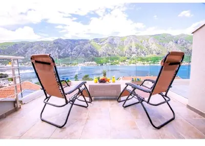 two chairs on a balcony with a view of the ocean at De Lux Apartments Sirena in Kotor