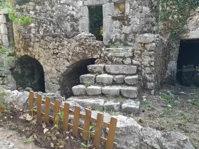an old stone building with a small wooden fence at centuries old Ethno House Đurović in Virpazar