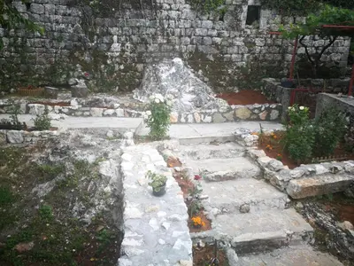 a stone pathway with a stone wall and some plants at centuries old Ethno House Đurović in Virpazar