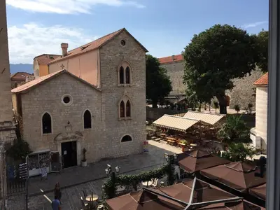 a large stone building with a market in front of it at Squere 44 Apartment in Budva