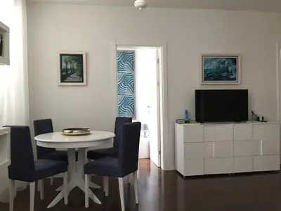 a living room with a table and chairs and a television at Squere 44 Apartment in Budva