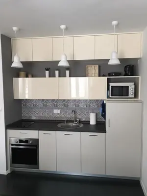 a kitchen with white cabinets and a sink and a microwave at Squere 44 Apartment in Budva