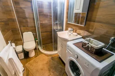 a bathroom with a washing machine and a toilet at Tramonto Apartments in Radanovići