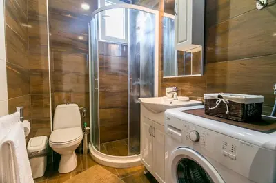 a bathroom with a toilet a sink and a washing machine at Tramonto Apartments in Radanovići