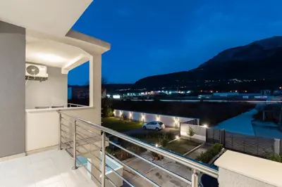 a balcony with a view of a river at night at Tramonto Apartments in Radanovići