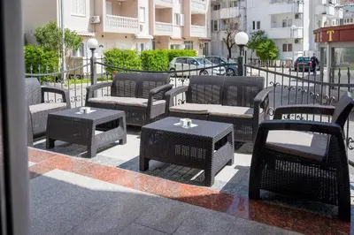 a group of wicker chairs and tables on a sidewalk at Garni Hotel MB in Budva