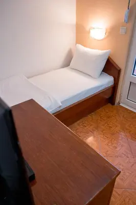 a small room with a bed and a table at Garni Hotel MB in Budva