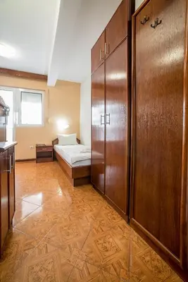 a room with a bed and a wooden cabinet at Garni Hotel MB in Budva