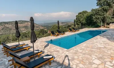 a swimming pool with chairs and umbrellas next to a pool at GRANDFATHER'S Secret in Danilovgrad