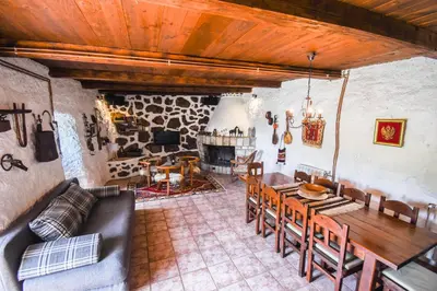 a living room with a table and chairs and a fireplace at GRANDFATHER'S Secret in Danilovgrad