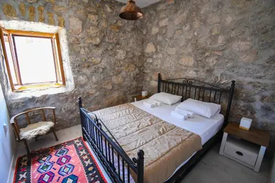 a bedroom with a bed in a stone wall at GRANDFATHER'S Secret in Danilovgrad