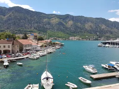 a sail boat is docked in a harbor with boats at S&I room in Kotor