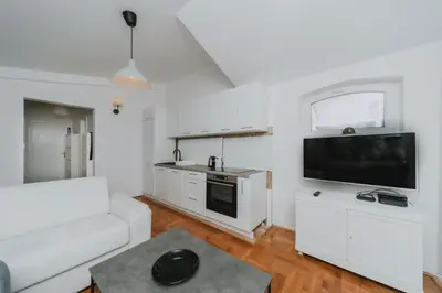 a living room with a white couch and a flat screen tv at Panoramic Apartment in Budva