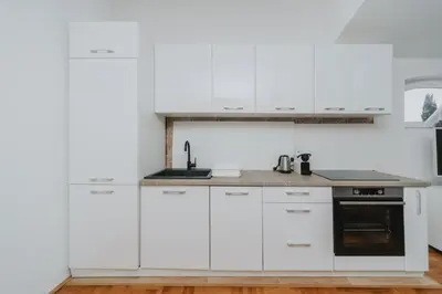 a white kitchen with white cabinets and a stove at Panoramic Apartment in Budva