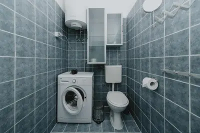 a bathroom with a washing machine and a toilet at Panoramic Apartment in Budva