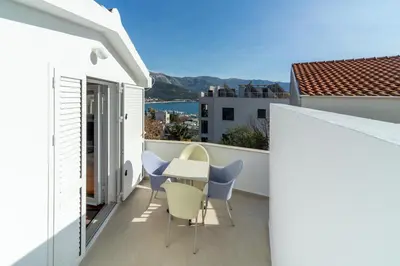 a balcony with a table and chairs on a building at Panoramic Apartment in Budva