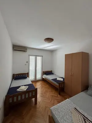 a room with two beds and a cabinet in it at Apartmani Bulevar in Budva