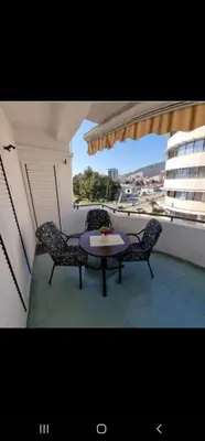 a balcony with a table and chairs and a window at Apartmani Bulevar in Budva