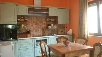 a kitchen with a table and a sink and a stove at Sole Apartments in Kotor
