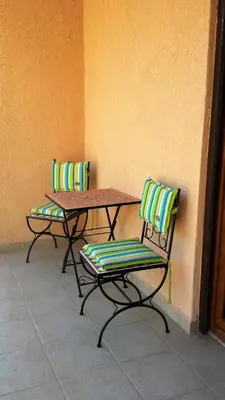 two chairs and a table next to a wall at Sole Apartments in Kotor