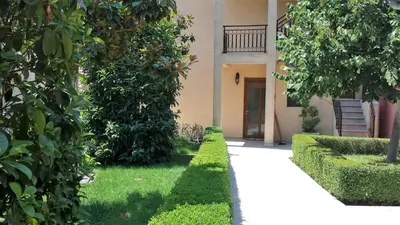 a walkway in front of a building with trees at Sole Apartments in Kotor