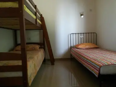 a bedroom with two bunk beds and a ladder at De Luxe Apartment with a Seaview in Petrovac na Moru