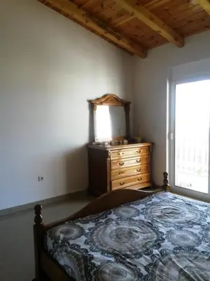a bedroom with a bed and a dresser and a window at De Luxe Apartment with a Seaview in Petrovac na Moru