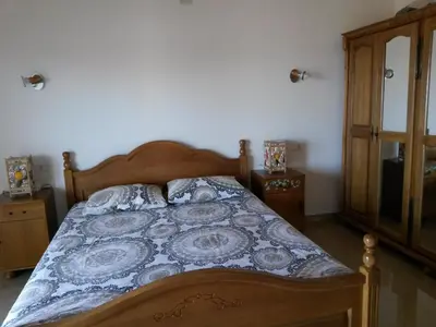a bedroom with a bed with a blue and white comforter at De Luxe Apartment with a Seaview in Petrovac na Moru