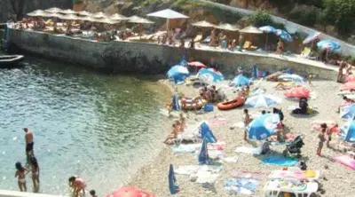 a group of people on a beach with umbrellas at Teuta Apartments in Ulcinj
