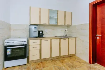 a kitchen with white cabinets and a sink and a stove at Teuta Apartments in Ulcinj