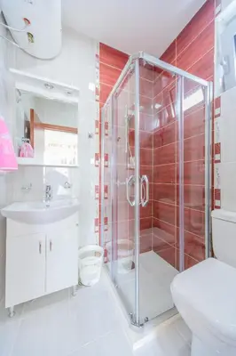 a bathroom with a shower and a toilet and a sink at Teuta Apartments in Ulcinj