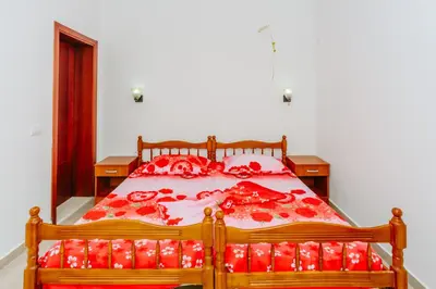 a bedroom with a large bed with red pillows at Teuta Apartments in Ulcinj