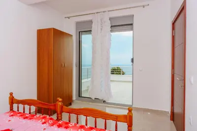 a bedroom with a window with a view of the ocean at Teuta Apartments in Ulcinj