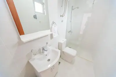 a white bathroom with a sink and a toilet at Teuta Apartments in Ulcinj