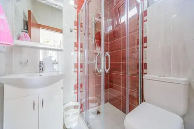 a bathroom with a shower and a toilet and a sink at Teuta Apartments in Ulcinj