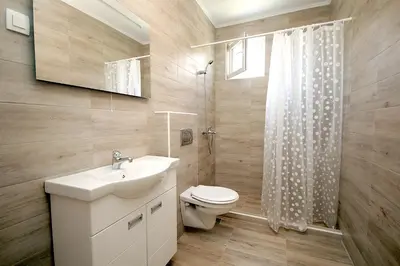 a bathroom with a toilet and a sink and a shower at Apartmani Begovic in Bar