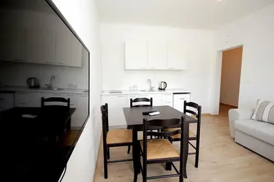a kitchen and dining room with a table and chairs at Apartmani Begovic in Bar
