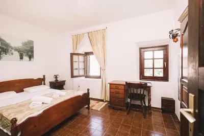 a bedroom with a bed and a desk and a chair at Kulla e Balshajve in Ulcinj