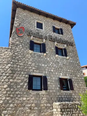 a tall stone building with a sign on it at Kulla e Balshajve in Ulcinj